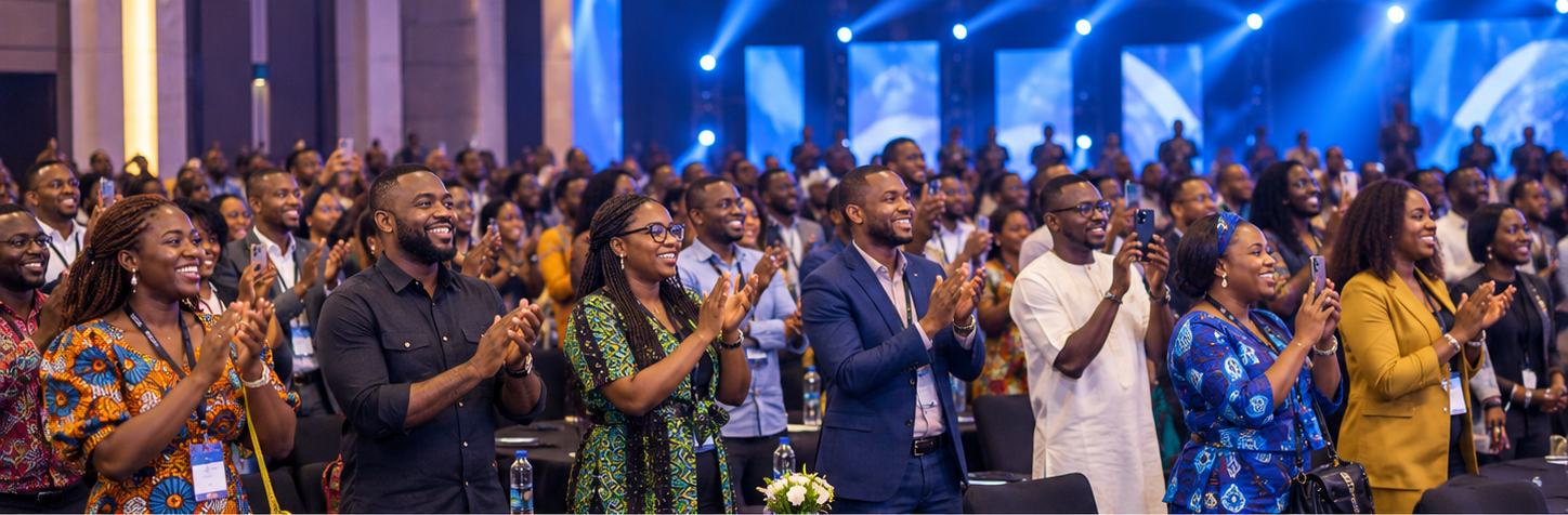 An energetic audience of Nigerian professionals applauding on stage at a conference